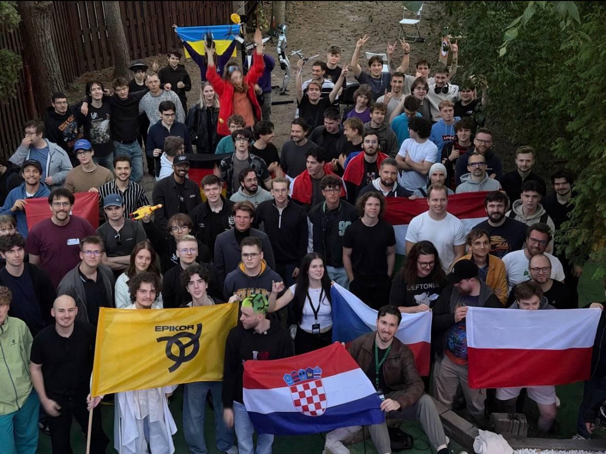 Group photo of Alien Bazaar participants in the garden, holding Epikor, Croatian, Czech and Polish flags