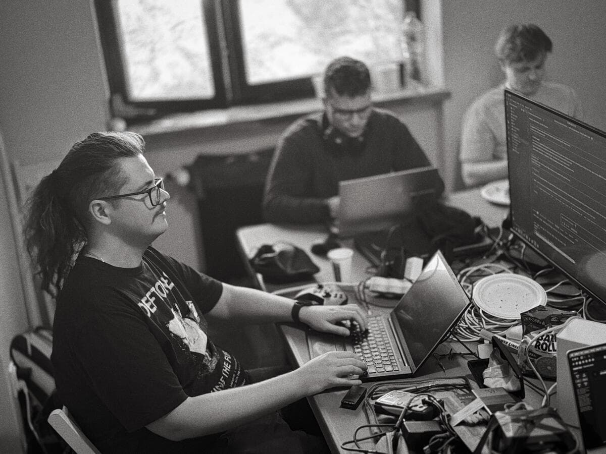 Participants at laptops surrounded by cables and hardware