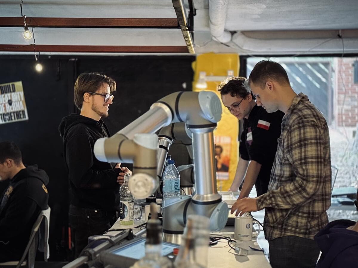 Three participants working on a robotic arm